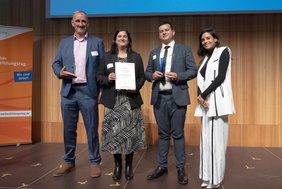 Die VHS Hanau ist in Berlin mit dem Deutschen Weiterbildungspreis in der Kategorie Integration ausgezeichnet worden (Foto v. l.): Uwe Hensel, Vorstand des Deutschen Weiterbildungstags e. V., Dr. Judith Lechner (VHS Hanau) mit Abdullah Kamandi, Praktikant Garten- und Landschaftsbau, der nach seiner Flucht aus Afghanistan dank der VHS auch beruflich in Hanau angekommen ist sowie Moderatorin und Schauspielerin Collien Monica Fernandes, Laudatorin für das Team der VHS Hanau.