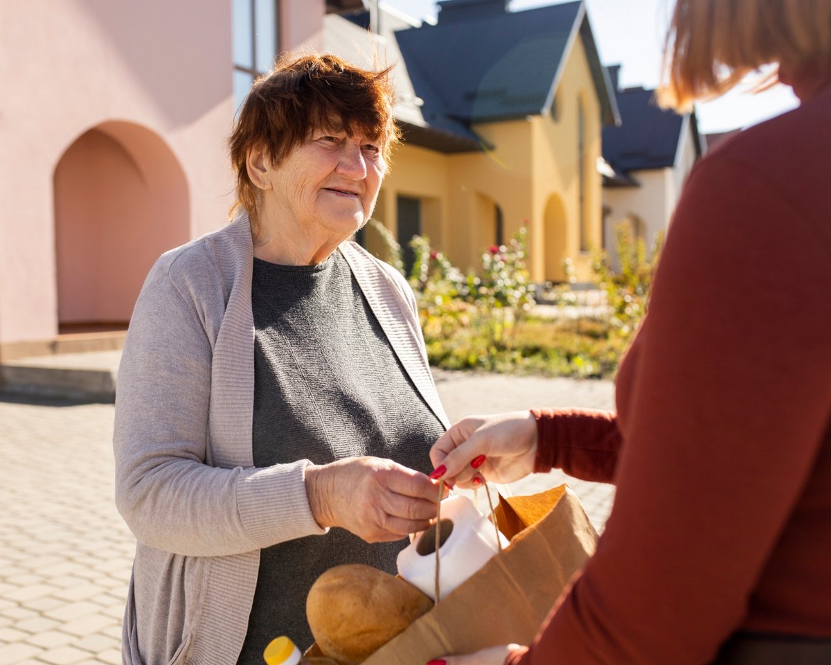 person-die-ihrem-aelteren-nachbarn-hilft